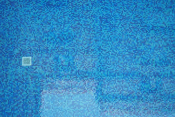 Technician removing thick calcium buildup from backyard pool tile before a weekend gathering, Pool technician cleaning heavy calcium buildup from backyard pool tile before a weekend gathering