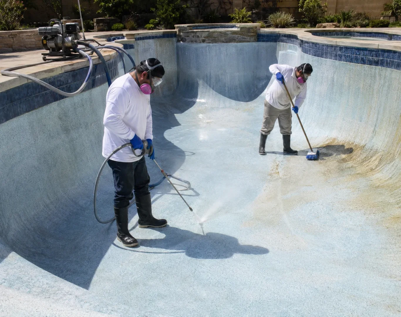 Pool professional inspecting etched plaster and calcium staining with close attention